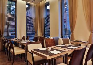 米兰贝斯特韦斯特麦迪逊酒店的餐厅设有木桌、椅子和窗户。