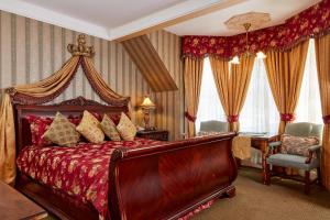 旧金山安妮女王酒店的一间卧室配有一张红色的大床和天蓬