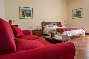 佩特拉利亚索普拉纳Hotel Residenza Petra的客厅配有红色的沙发和床。