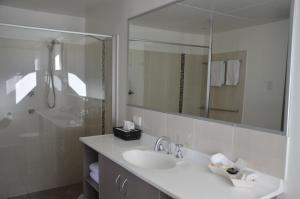 土乌巴阳光汽车旅馆的白色的浴室设有水槽和镜子