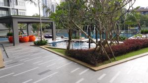 吉隆坡旺萨玛珠阿德纳公寓的一个带游泳池和树木的庭院和一座建筑