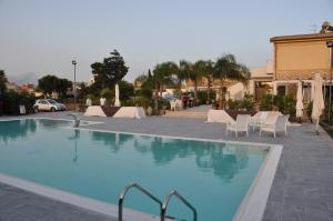 里里耶沃基拉蒂尼艾伦科斯塔住宿加早餐旅馆的一个带白色椅子和桌子的大型游泳池