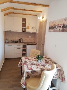 科托尔Apartments Peranovic 2的一间带桌椅的厨房和一间带白色橱柜的厨房