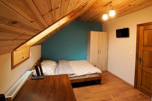 Krajno-ZagórzeNoclegi Azyl的一间卧室设有一张床和木制天花板