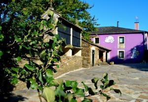 卢戈Casa de Baixo的一座有紫色建筑和树的房子