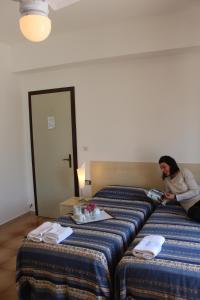 奥特朗托Il Gabbiano的坐在酒店房间床上的女人