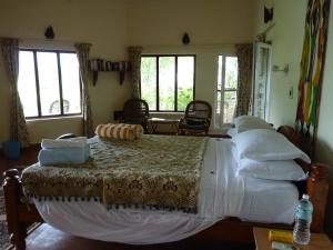 Sembatti豆蔻之家旅馆的卧室配有一张带白色床单和窗户的大床。