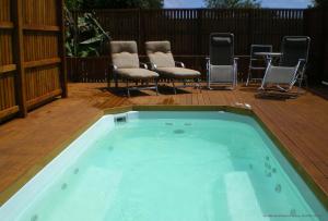 彭特派因坎伯兰度假村&Spa的甲板上的热水浴池配有椅子和椅子
