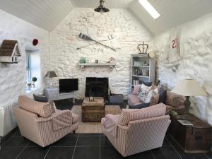 DoogortThe Old Beach Cottage, Achill的客厅配有两把椅子和石墙