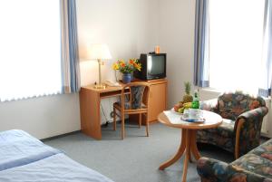 瓦伦英格堡酒店的一间酒店客房,配有一张床铺、一张桌子和一台电视