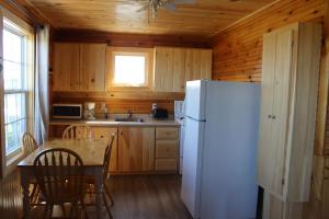 北拉斯蒂科Chalets Grand Pre Cottages的厨房配有白色冰箱和桌子
