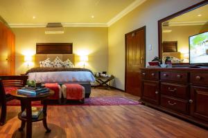 比勒陀利亚Spacube Luxury Suites and Spa的一间卧室配有一张床、梳妆台和电视。