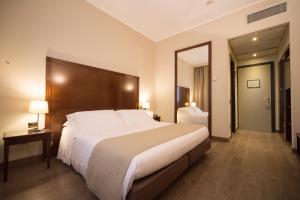 利索内莫泰阿斯科特酒店的一间卧室设有一张大床和一个大镜子