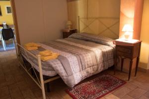 CupramontanaLo Sfizio B&B的一间卧室配有一张床和一张桌子,上面配有毛巾