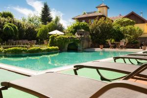 阿特湖畔努斯多夫埃彻格精品酒店的一个带两把椅子的游泳池以及一座房子