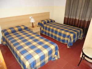 托里代巴拉拉莫加奥纳酒店的酒店客房设有两张床和一张桌子。