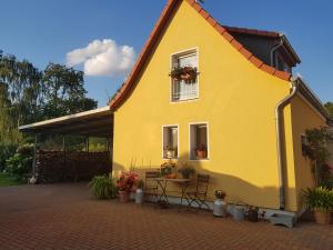马格德堡Kleines Zuhause的黄色房子前面有桌子