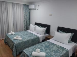 巴统思维里巴图米酒店的两张位于酒店客房的床,配有毛巾