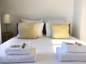 里斯本Casa da Maria Alfama的一张带毛巾和枕头的白色床