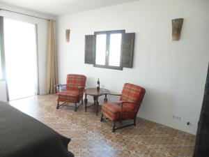 埃尔乔罗乔罗住宿加早餐旅馆的一间设有两把椅子、一张桌子和一个窗户的房间