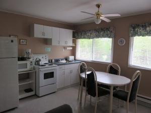 CormackLush's Cottages的厨房配有桌子和白色冰箱。