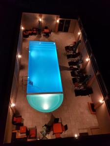 穆龙达瓦Select Hôtel的配有桌椅的客房享有游泳池的顶部景致。