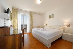 布雷拉Apartmens Villa Antonio 88的卧室设有白色的床和大窗户