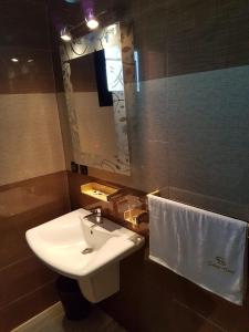 穆龙达瓦Select Hôtel的一间带水槽、镜子和毛巾的浴室