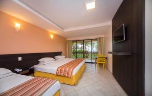 阿拉卡茹Makai Resort All Inclusive Convention Aracaju的酒店客房设有两张床和电视。