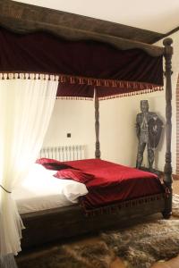 顿河畔罗斯托夫普罗蒙纳精品酒店 的一间卧室配有一张天蓬床和一尊男爵的雕像