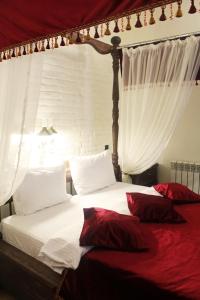 顿河畔罗斯托夫普罗蒙纳精品酒店 的一间卧室配有带白色床单和红色枕头的床。