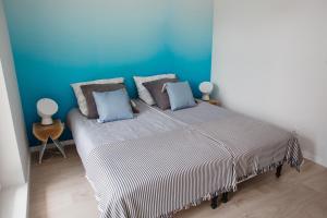 尤斯托尼莫斯基Apartament Aqua Ustronie Morskie的一间卧室设有一张蓝色墙壁的大床