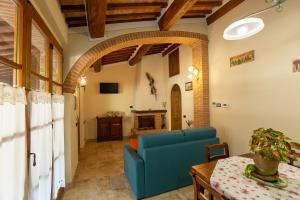 蒙特普齐亚诺Borgo Poggiardelli的客厅配有蓝色的沙发和桌子