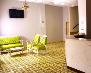 巴兰基亚Hotel Med Centro - Marcari的一间设有绿色沙发和椅子的等候室