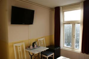 阿姆斯特丹维斯特图伦酒店的一间房间,墙上设有一张桌子和一台电视机