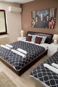 尼什矿泉村Apartments Cvetkovic Relax的一间卧室配有一张大床,铺有黑白床单。