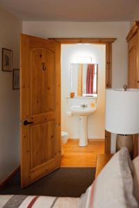 Sharbot LakeRock Hill Bed & Breakfast的一间带木门和水槽的浴室