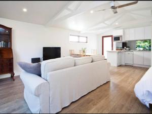FreshwaterBijoux Beach House的白色的客厅配有白色的沙发,厨房