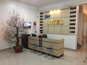 Uông BíSky hotel 390 QUang Trung Thành phố Uông Bí tỉnh Quảng Ninh的坐在商店前台的一个女人