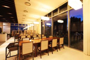 仁川市Bridge Hotel Incheon Songdo的一间带长桌和椅子的用餐室