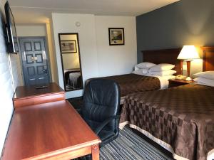 代顿Knights Inn Dayton by Miller Lane的酒店客房 - 带两张床、一张桌子和一把椅子
