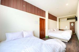 小琉球岛小琉球觀海洋客棧View Ocean Inn的配有白色床单的客房内的两张床