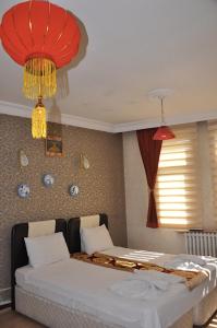 科尼亚MEVLANA ŞEMS HOTEL的一间卧室配有床和2个吊灯