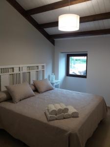 拉赫A Casa de Elisa的一间卧室配有一张大床和两条毛巾