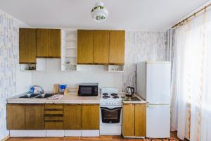 赤塔Dekabrist Apartment Oktyabrski的厨房配有木制橱柜和白色冰箱。