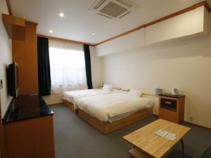 南淡路市Awajishima Hotel Lodge GREEN COZY的酒店客房,配有床和电视