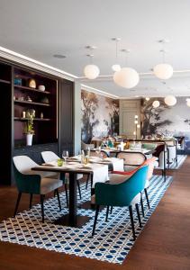 勒图凯-巴黎普拉日庄园酒店的一间铺着地毯的餐厅,配有桌椅