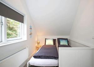 海滨诺德韦克Salt Life Beachhouse的一间小卧室,配有床和窗户