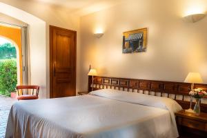 圣特罗佩罗马丽娜酒店的一间卧室设有一张大床和一个窗户。