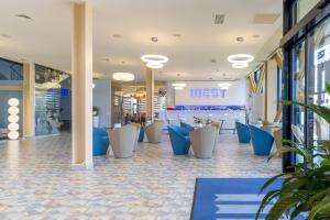 克卢日-纳波卡西城酒店的大堂设有蓝色和白色的椅子,位于商店